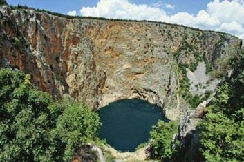 Figure 11: Crveno Jezero (Red Lake), a Croatian solution lake, formed when slightly acidic water dissolved the soft limestone in the ground. clip_image022