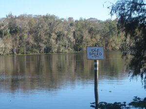 Sign indicating an "idle speed" or "o-wake zone for boaters on the St. Johns River in Astor, Florida, USA.